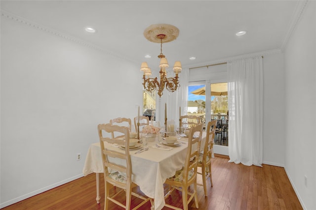 dining space featuring a notable chandelier, baseboards, and wood finished floors