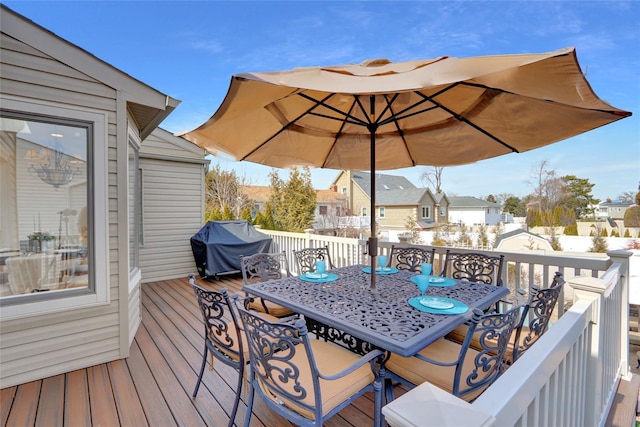 deck with outdoor dining area, area for grilling, fence, and a residential view