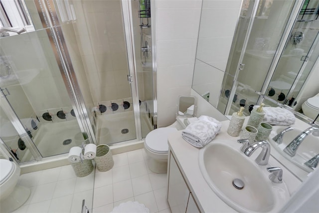 bathroom featuring vanity, a shower stall, toilet, and tile patterned floors