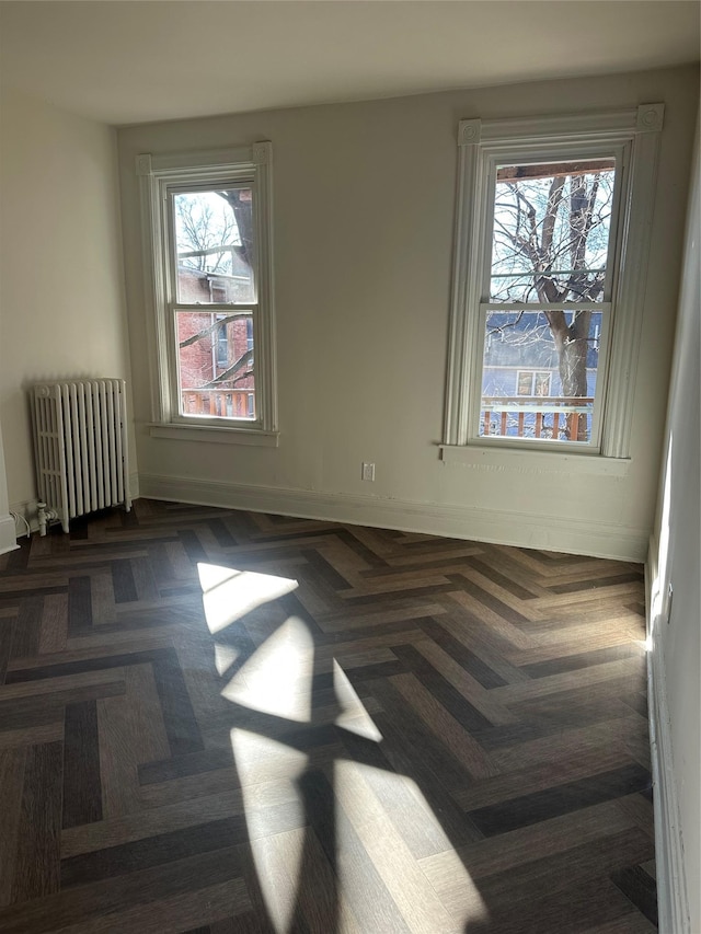 empty room with baseboards and radiator