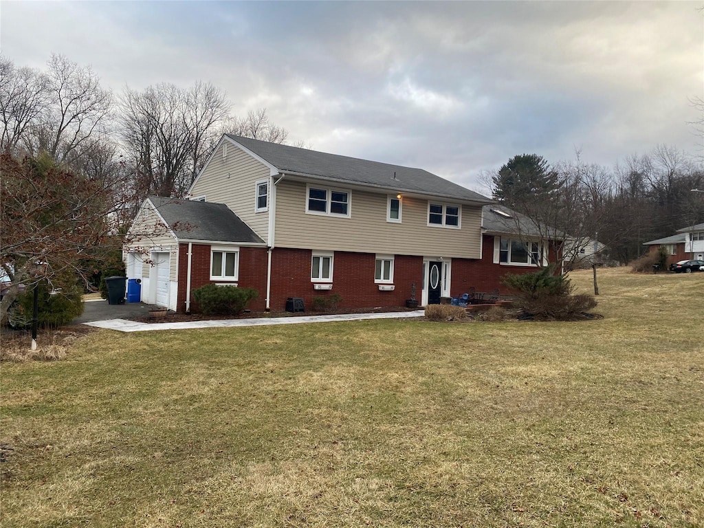 view of front facade featuring a garage, brick siding, and a front yard