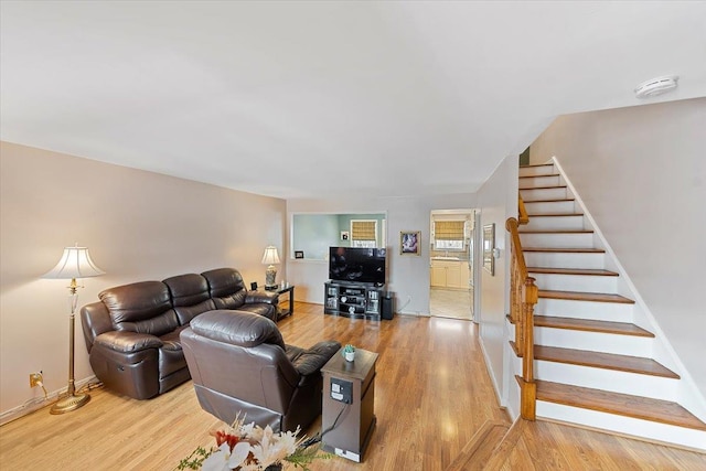 living room with stairs, baseboards, and wood finished floors