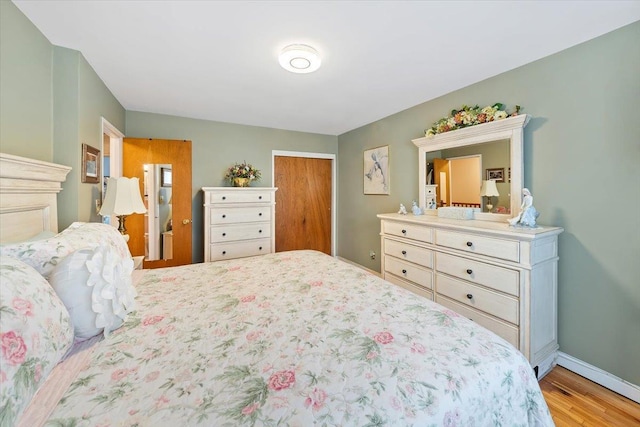 bedroom with a closet, baseboards, and wood finished floors