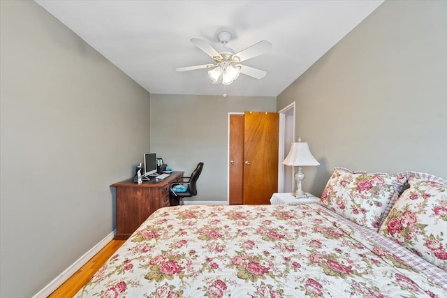 bedroom featuring a ceiling fan, baseboards, and wood finished floors