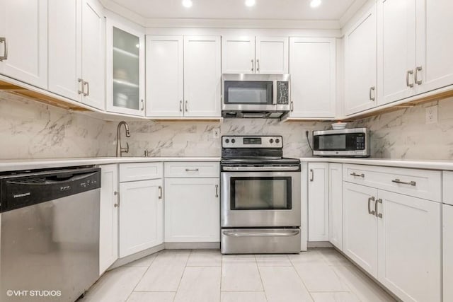 18 Old Farm Rd, Levittown, NY 11756 - kitchen with appliances with stainless steel finishes, light countertops, white cabinets, tasteful backsplash, and recessed lighting
