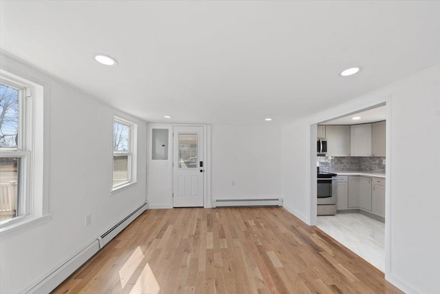 unfurnished living room featuring baseboards, baseboard heating, light wood-type flooring, and recessed lighting