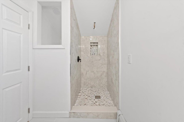 full bathroom featuring baseboards and a tile shower