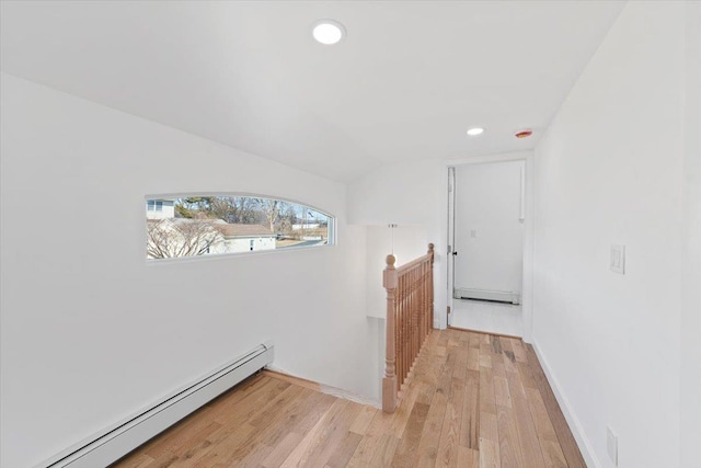 corridor featuring lofted ceiling, a baseboard radiator, recessed lighting, an upstairs landing, and light wood-type flooring