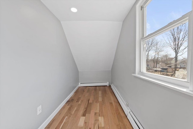 interior space featuring a healthy amount of sunlight, a baseboard radiator, baseboards, and light wood-style flooring