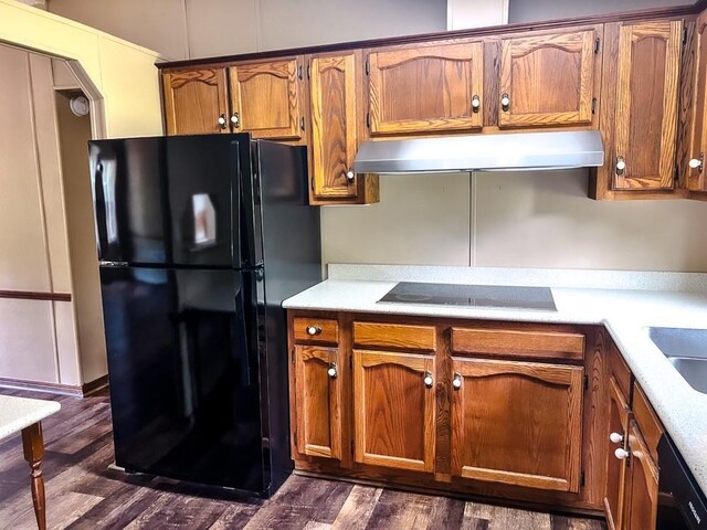 521 Hessinger Lare Rd, Jeffersonville, NY 12748 - kitchen with black appliances, under cabinet range hood, brown cabinetry, light countertops, and dark wood finished floors