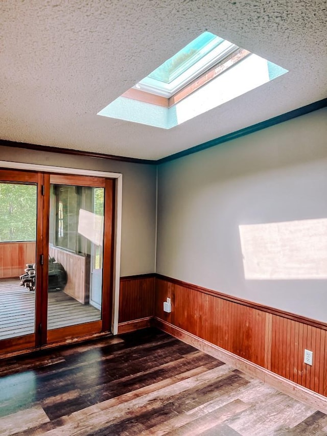 521 Hessinger Lare Rd, Jeffersonville, NY 12748 - empty room featuring a skylight, wood finished floors, a textured ceiling, wainscoting, and wood walls