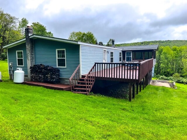 521 Hessinger Lare Rd, Jeffersonville, NY 12748 - rear view of property featuring a deck, a lawn, and a chimney