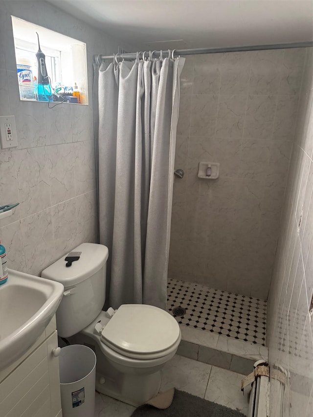 bathroom with toilet, a shower stall, tile walls, and vanity