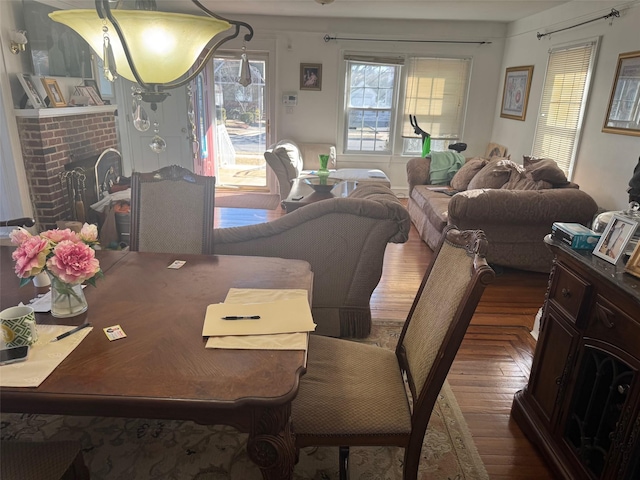 dining area featuring a brick fireplace and parquet flooring