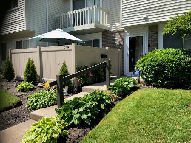 view of yard featuring a balcony and fence