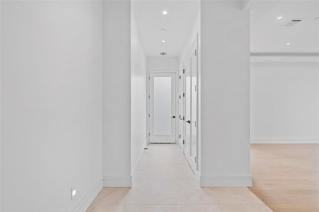 hall with recessed lighting, visible vents, and baseboards