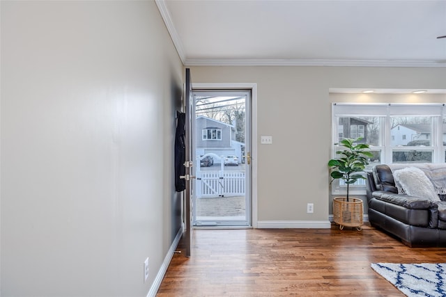 doorway to outside featuring ornamental molding, baseboards, and wood finished floors