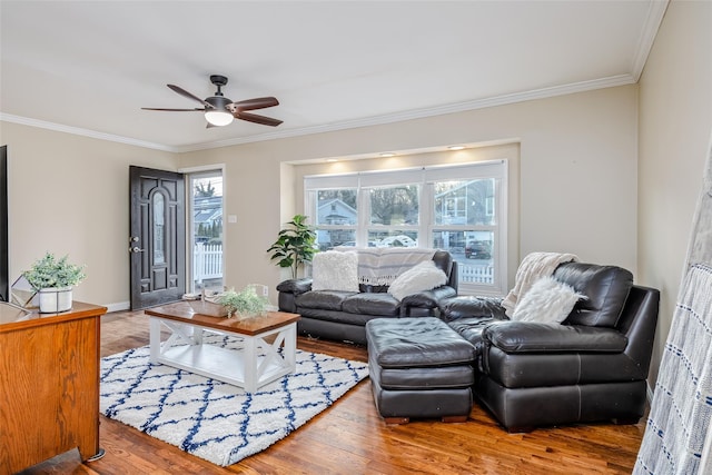 living room with ornamental molding, wood finished floors, a ceiling fan, and baseboards