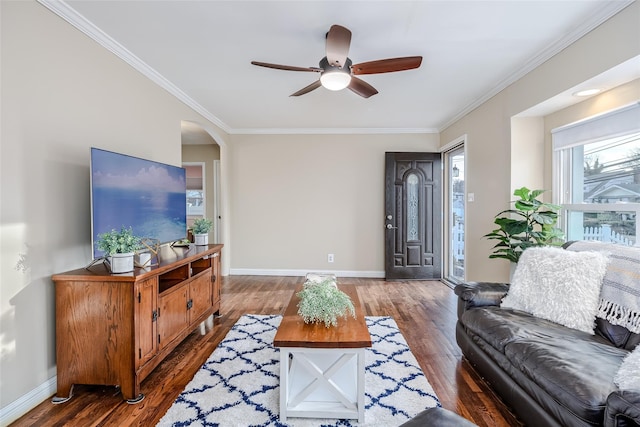 living area featuring arched walkways, crown molding, baseboards, and wood finished floors