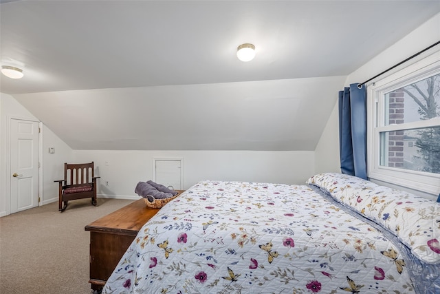 carpeted bedroom with baseboards and vaulted ceiling