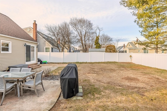 view of yard featuring entry steps, a patio, and a fenced backyard