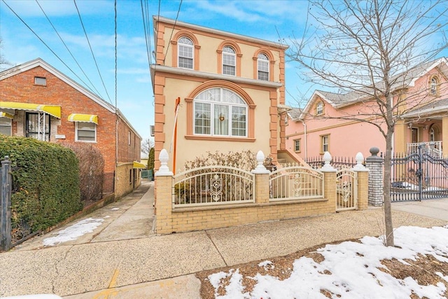 view of front of home featuring a fenced front yard, a gate, and stucco siding