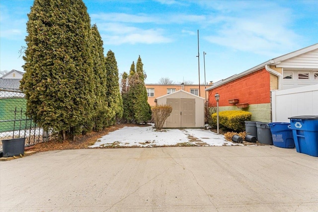 exterior space featuring a garage, a storage unit, fence, and an outdoor structure