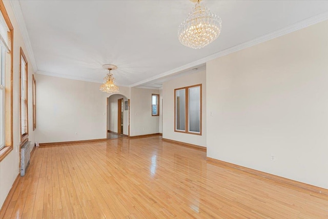 unfurnished room with arched walkways, ornamental molding, a chandelier, and light wood-style flooring