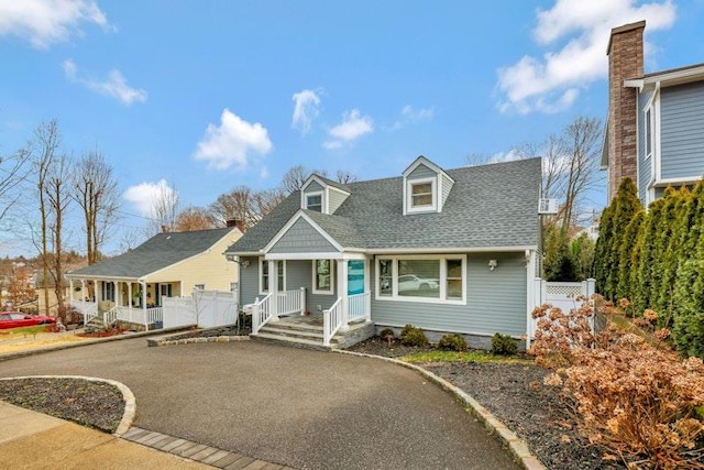 view of front of house with a shingled roof and fence