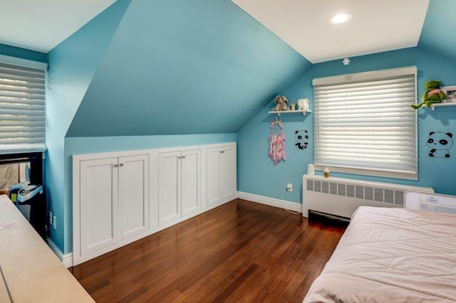 bedroom with radiator heating unit, vaulted ceiling, baseboards, and dark wood finished floors