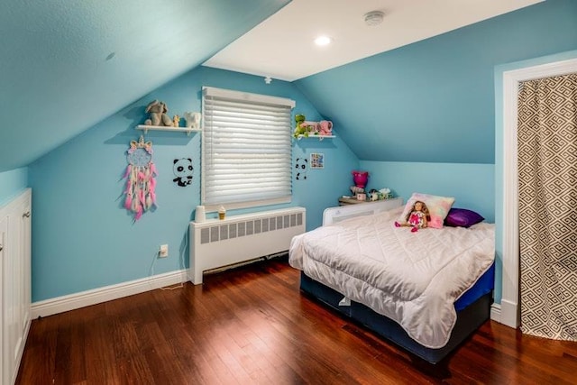 bedroom with lofted ceiling, radiator heating unit, wood finished floors, and baseboards