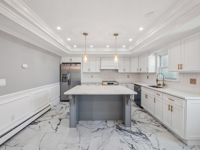 kitchen with a tray ceiling, stainless steel appliances, baseboard heating, wainscoting, and a sink