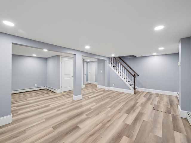 finished below grade area featuring light wood-style floors, baseboards, stairway, and recessed lighting