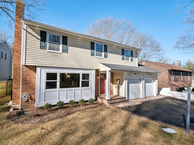 view of front of property with aphalt driveway, brick siding, a chimney, and an attached garage