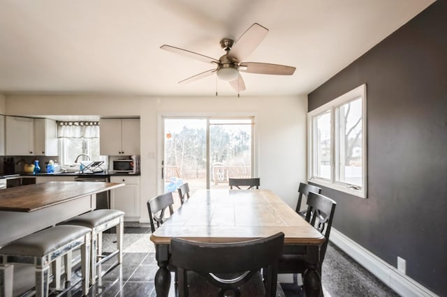 dining room with a ceiling fan and baseboards