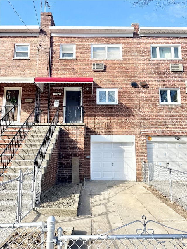 view of property featuring a garage, driveway, and brick siding