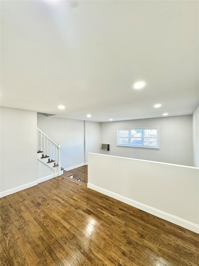 below grade area with stairs, baseboards, wood finished floors, and recessed lighting