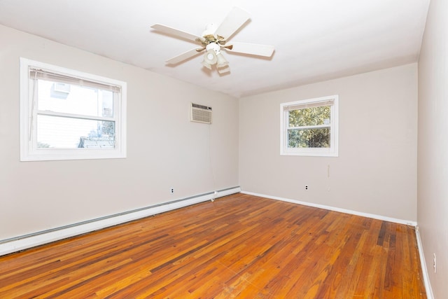 empty room with baseboards, ceiling fan, wood-type flooring, baseboard heating, and a wall mounted AC