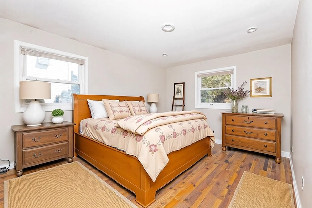 bedroom with baseboards, light wood finished floors, and recessed lighting