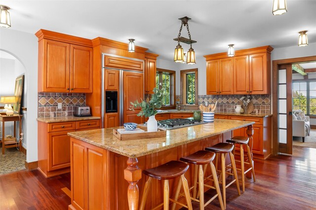 5 Shingle House Rd, Millwood, NY 10546 - kitchen featuring paneled built in refrigerator, dark wood finished floors, arched walkways, decorative backsplash, and brown cabinets