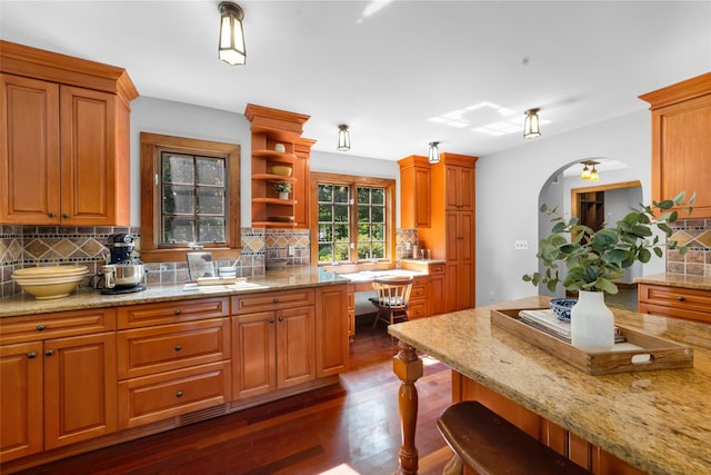 5 Shingle House Rd, Millwood, NY 10546 - kitchen featuring dark wood finished floors, tasteful backsplash, arched walkways, a breakfast bar, and light stone countertops
