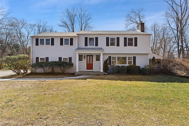 view of front of home with a front lawn and a chimney