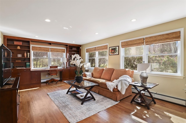 living room with recessed lighting, a baseboard radiator, wood finished floors, and built in study area