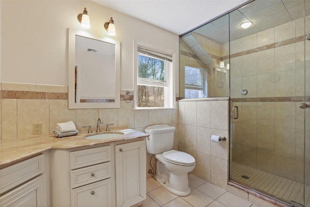 full bath featuring a shower stall, tile walls, toilet, tile patterned floors, and vanity