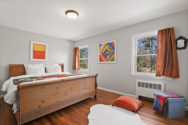 bedroom featuring dark wood finished floors, radiator, and baseboards