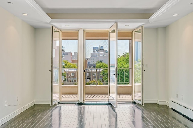 entryway featuring a view of city, baseboard heating, wood finished floors, and baseboards