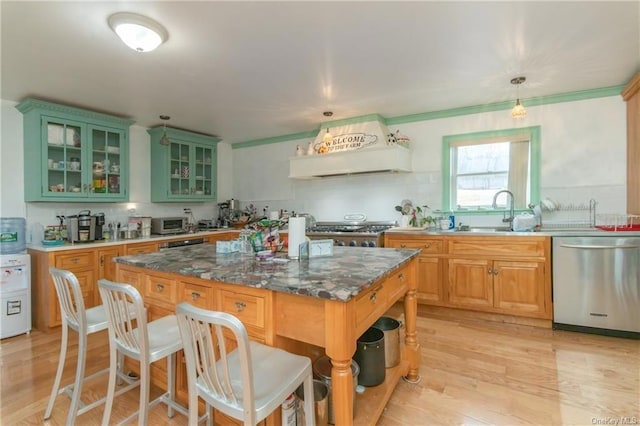 kitchen featuring range, custom range hood, a breakfast bar area, stainless steel dishwasher, and a sink