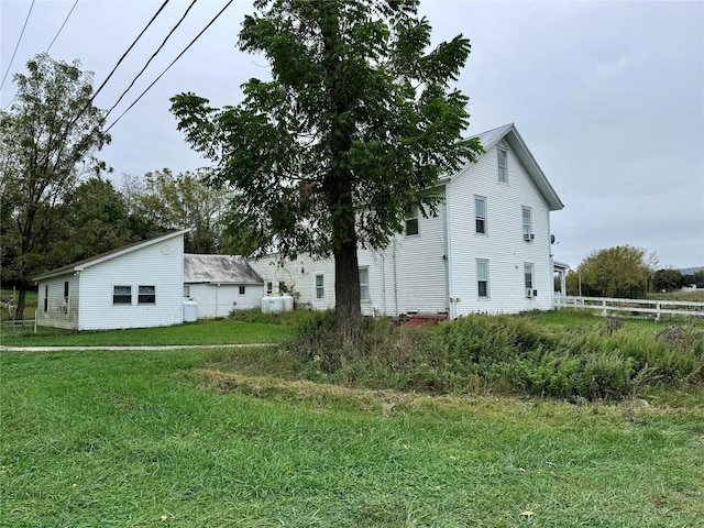 view of property exterior with a yard and fence