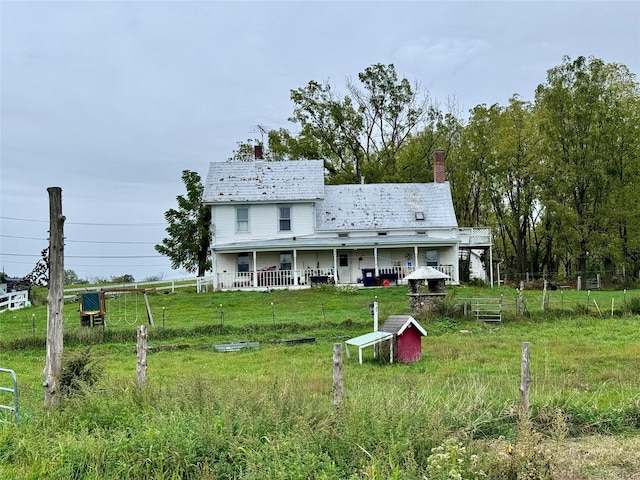 back of house with a chimney and fence