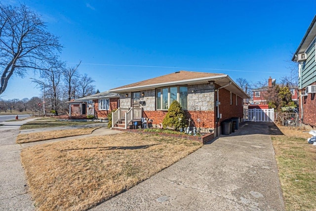 view of front of property with stone siding, brick siding, and driveway